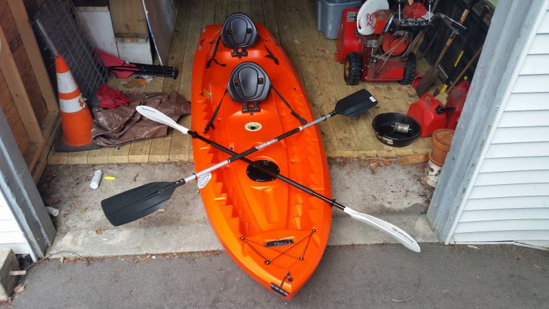 Orange kayak in a garage.