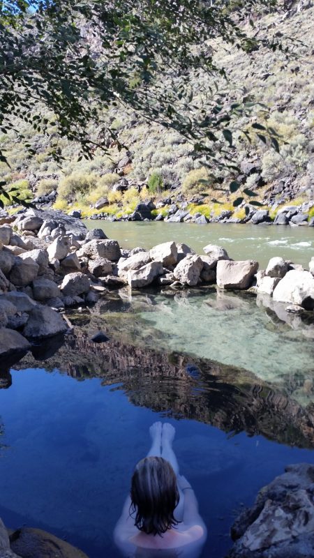 A woman soaking in a pool of hot spring water near Taos New Mexico.