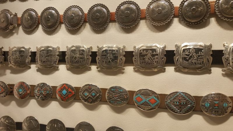 A display of many intricate silver belt buckles from Museum Hill in Santa Fe.