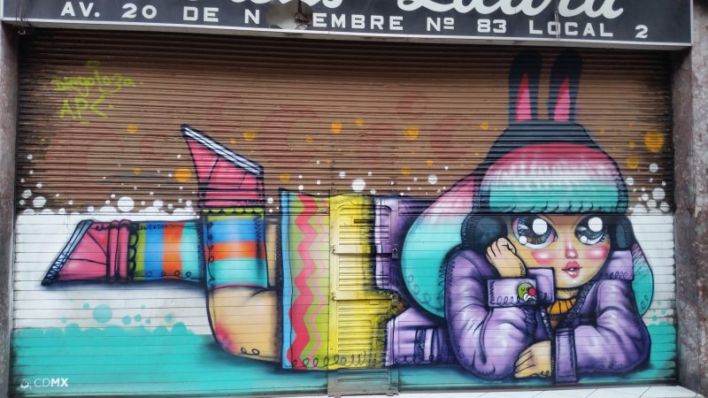 Street art in Mexico City showing a cartoonish image of a young girl daydreaming.