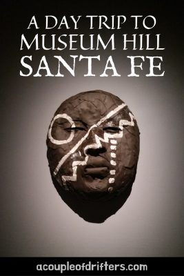 A black and white mask hanging on a wall at a museum in Santa Fe.