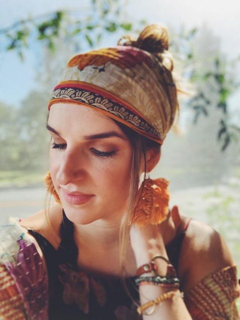 A woman wearing a multi-colored head covering.