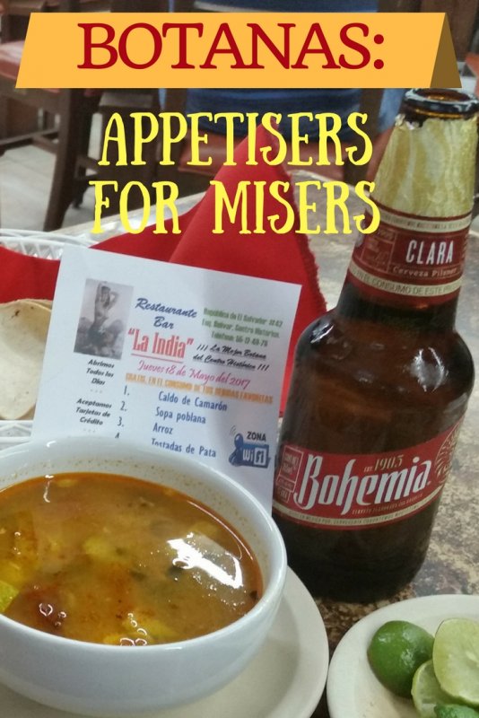 bowl of soup and bottle of beer on a table.