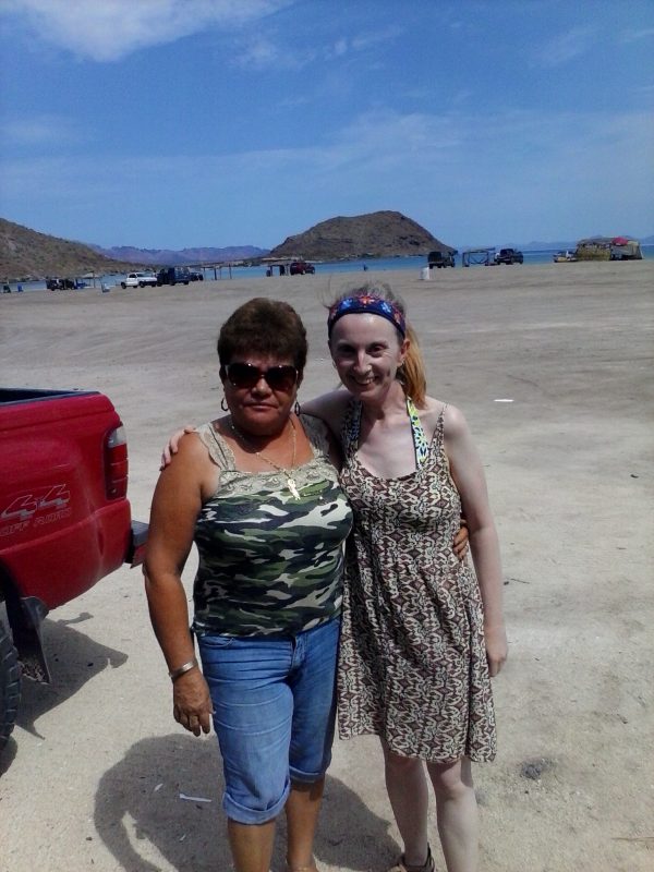 Two women standing on Santispac Beach.