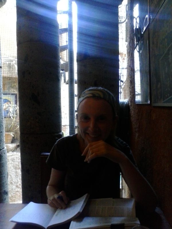 A smiling woman sitting in the bar Clave Azul in Guanajuato, Mexico.