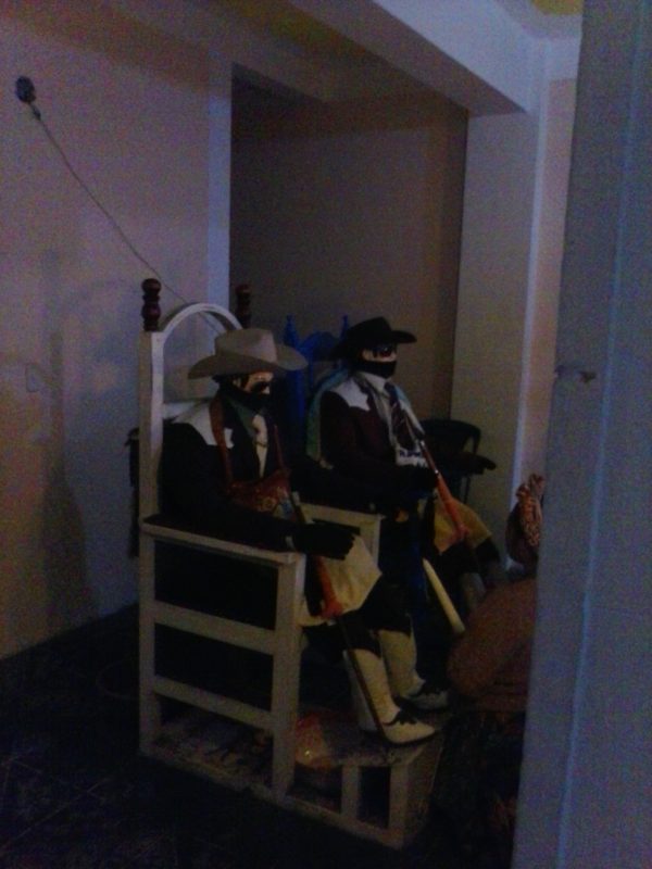 The likeness of San Simon in Zunil, Guatemala, wearing a sombrero and sunglasses, as is typical.