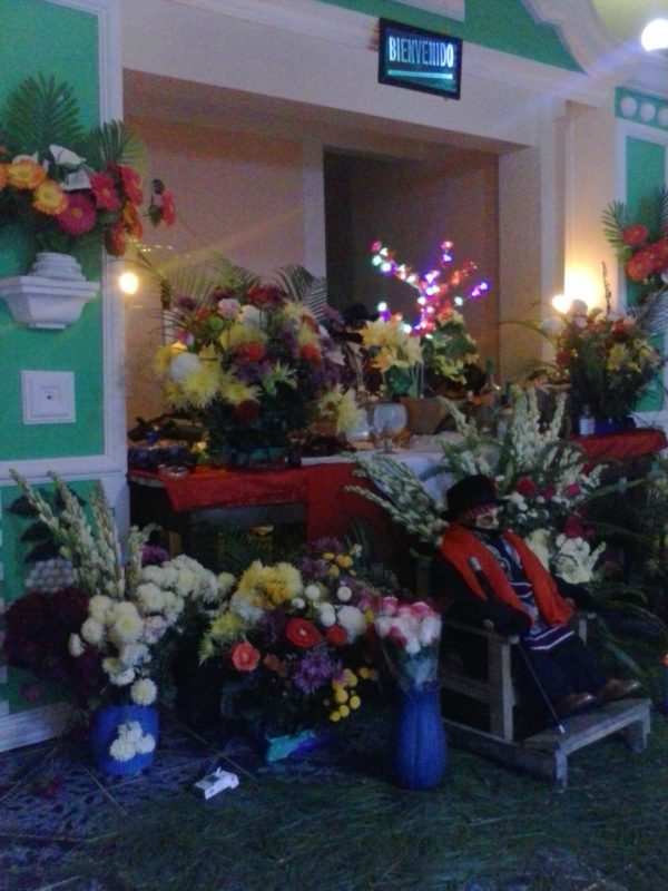 Flowers in front of a likeness of San Simon in Zunil, Guatemala.