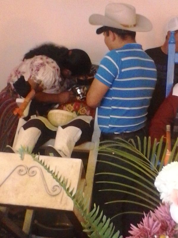 A man and woman pouring spirits into the mouth of San Simon in Zunil, Guatemala.