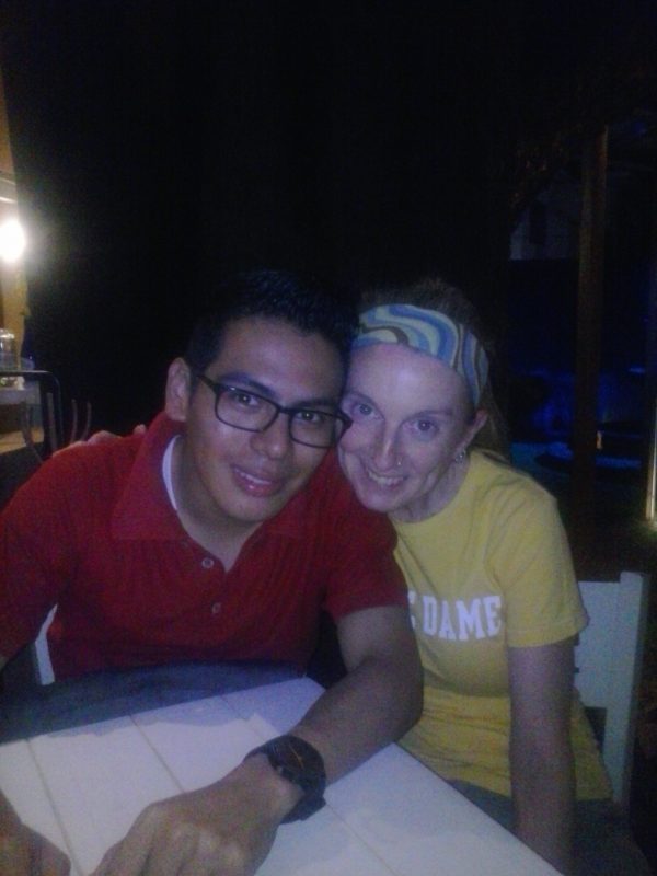 Man in red shirt and woman in yellow shirt posing for a photo.