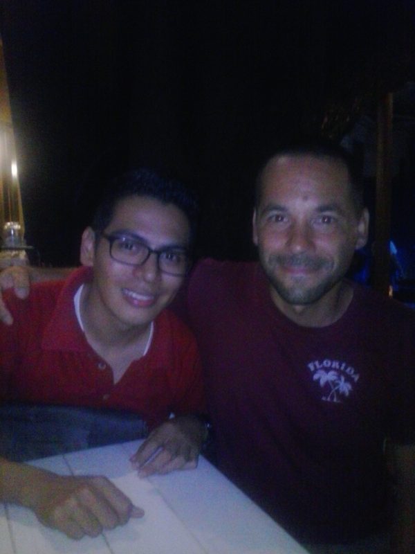 Two men in red shirts posing for a photo.