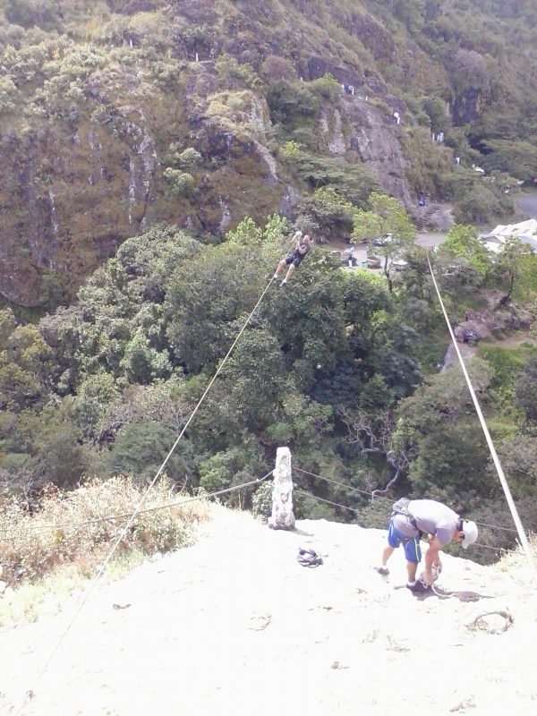 A man preparing a zip line at an overlook in San Salvador, El Salvador.