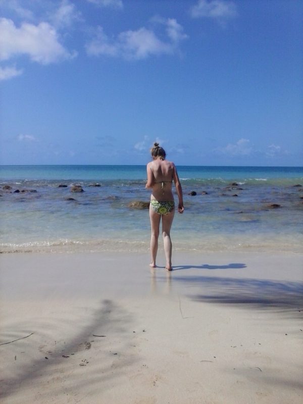 A woman walking into the water at a beach on Big Corn Island off the coast of Nicaragua.