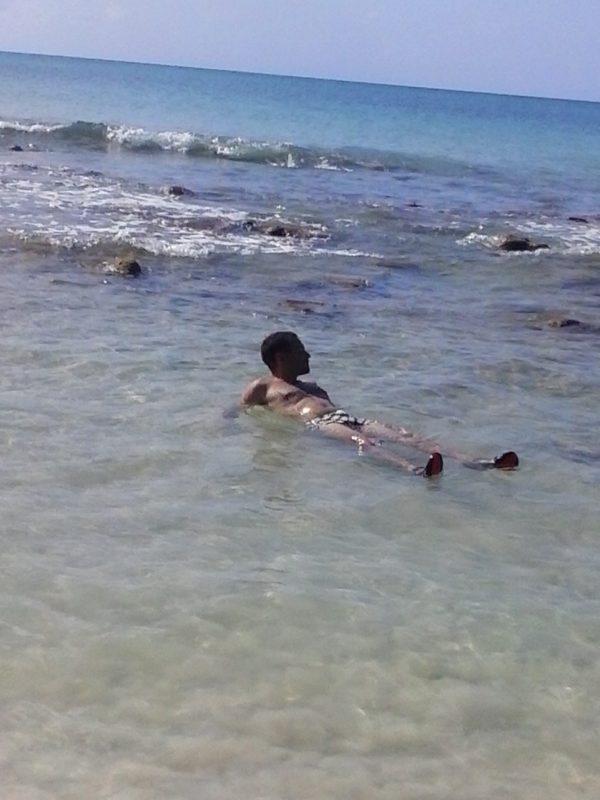 A man lying in shallow water on Big Corn Island off the coast of Nicaragua.