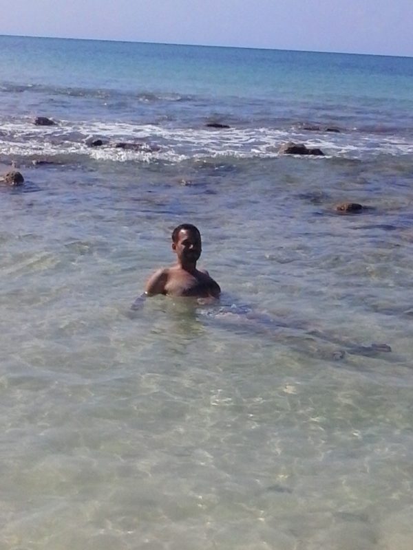 A man lying in shallow water on Big Corn Island off the coast of Nicaragua.