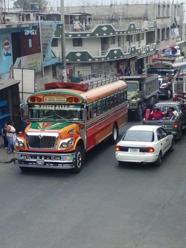 A colorful school bus in traffic.