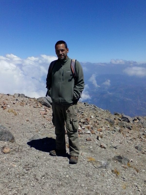 A man wearing a green fleece smiling after hiking Volcan Tajumulco.