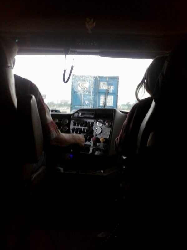 Two people in the front seat of a truck.