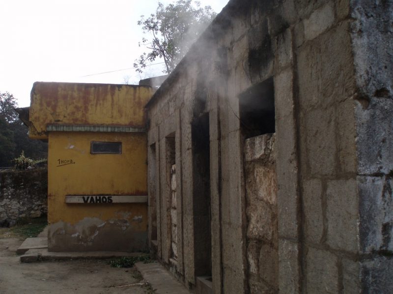 A concrete sauna building with steam coming out the widows and doors near Xela, Guatemala.