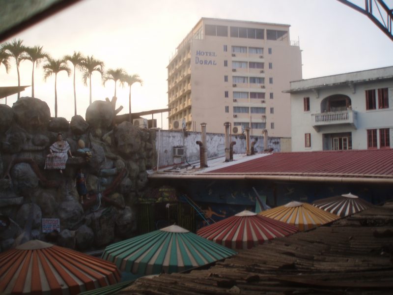 View of a large hotel building with several colorful parasols in the foreground.
