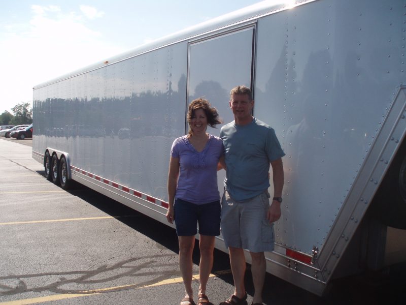 Man and woman standing in front of a trailer.